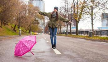 jong vrouw wandelen met paraplu in herfst regenachtig dag foto