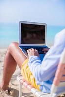 jonge man aan het werk op laptop op tropisch strand foto