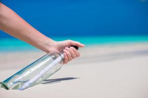 fles met een bericht begraven in de wit zand foto