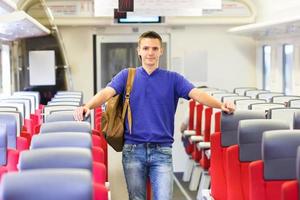 jong gelukkig Mens op reis door trein foto