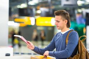 mooi Mens met paspoorten en instappen passeert Bij de voorkant bureau Bij luchthaven foto