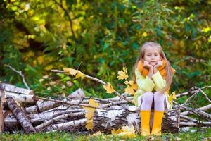 schattig klein meisje buitenshuis op mooie herfstdag foto