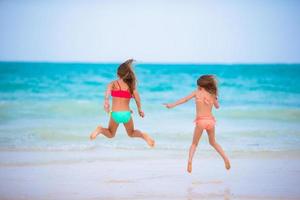 kinderen hebben pret Bij tropisch strand gedurende zomer vakantie foto