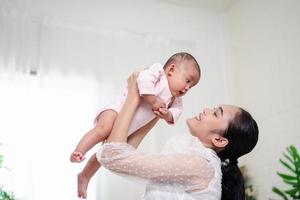 moeder ouderschap en pasgeboren geboorte leven. mam en baby jongen spelen in zonnig slaapkamer, familie hebben pret samen. kinderopvang, moederschap concept. foto