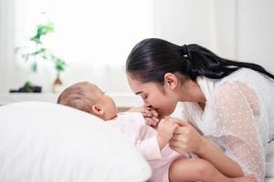 moeder ouderschap en pasgeboren geboorte leven. mam en baby jongen spelen in zonnig slaapkamer, familie hebben pret samen. kinderopvang, moederschap concept. foto