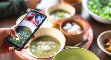 vrouw hand- gebruik een smartphone naar nemen foto met de lokaal voedsel van de top visie.