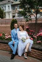 bruid in een licht bruiloft jurk naar de bruidegom in een blauw pak foto