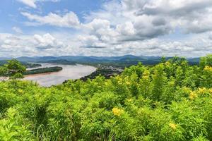 panorama van het prachtige landschap van thailand - uitzicht op de bergplant en gele bloemen met rivier en blauwe luchtachtergrond foto