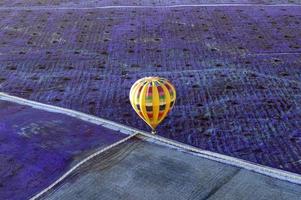 vliegend in een geel heet lucht ballon over- velden van lavendel geven strak contrast van kleur en textuur. foto