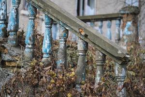 een balustrade Aan de traliewerk van een oud gebarsten trappenhuis foto