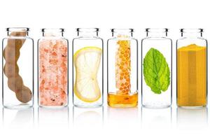 de glas fles van eigengemaakt huid zorg en lichaam scrubs met natuurlijk ingrediënten aloë vera , Himalaya zout ,pepermunt , rozemarijn ,kurkuma en honing isoleren Aan wit achtergrond. foto