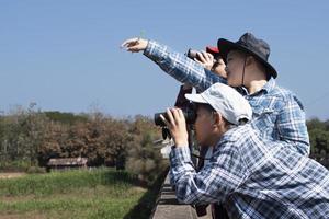 Aziatisch jongens zijn gebruik makend van kijker naar Doen de vogels aan het kijken in tropisch Woud gedurende zomer kamp, idee voor aan het leren schepsels en dieren in het wild dieren en insecten buiten de klas. foto