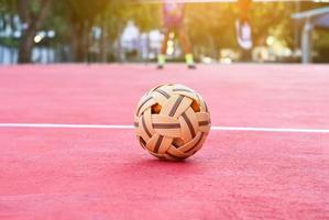 sepak takraw bal Aan rood verdieping van buitenshuis rechtbank, wazig achtergrond, recreatief werkzaamheid en buitenshuis sport- in zuidoosten Aziatisch landen concept. foto