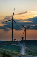 wind turbines over- een zonsondergang achtergrond. foto