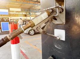 detailopname gas- dispenser voor auto- Aan wazig klanten Bij gas- station met zon gloed achtergrond. foto