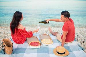 lief jong paar hebben een picknick Bij de strand foto