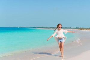 aanbiddelijk gelukkig weinig meisje hebben pret Aan strand vakantie foto