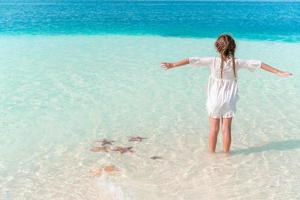 aanbiddelijk gelukkig weinig meisje hebben pret Aan strand vakantie foto