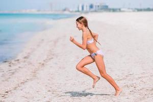 schattig weinig meisje Bij strand gedurende caraïben vakantie foto