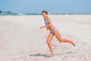 schattig weinig meisje Bij strand gedurende caraïben vakantie foto