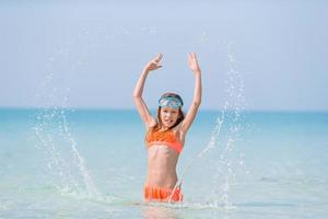 schattig weinig meisje Bij strand gedurende caraïben vakantie foto