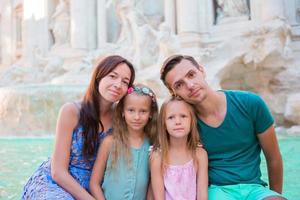 portret van familie Bij fontana di trevi, Rome, Italië. gelukkig ouders en kinderen genieten Italiaans vakantie vakantie in Europa. foto