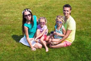 gelukkig familie met twee kinderen buitenshuis Aan zomer dag foto