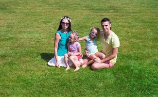 gelukkig familie met twee kinderen buitenshuis Aan zomer dag foto