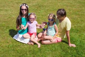 gelukkig familie met twee kinderen buitenshuis Aan zomer dag foto