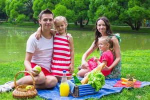 gelukkig jong familie picknicken buitenshuis foto