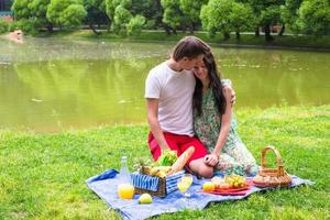 jong gelukkig paar picknicken buitenshuis foto