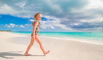 aanbiddelijk weinig meisje Bij Ondiep water Aan de strand foto