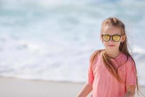 portret van aanbiddelijk weinig meisje Bij strand gedurende zomer vakantie foto