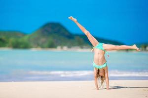 schattig actief meisje op het strand tijdens de zomervakantie foto