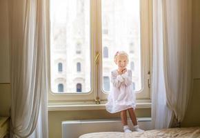 aanbiddelijk weinig meisje op zoek uit de venster Bij duomo, Milaan, Italië foto