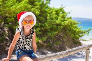 schattig mooi weinig meisje in de kerstman hoed gedurende vakantie foto
