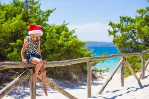 schattig mooi weinig meisje in de kerstman hoed gedurende vakantie foto