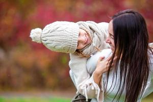 weinig meisje met mam buitenshuis in park Bij herfst dag foto