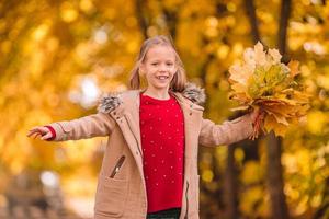 portret van aanbiddelijk weinig meisje met geel bladeren boeket in vallen foto