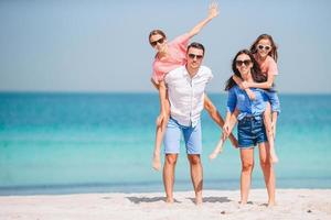 gelukkig familie Aan de strand gedurende zomer vakantie foto