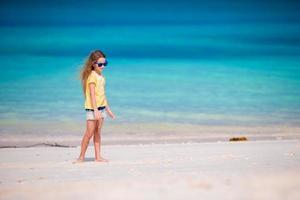 schattig klein meisje op het strand tijdens de zomervakantie foto