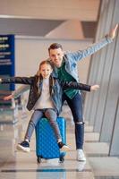 gelukkig familie met bagage en instappen voorbij gaan aan Bij luchthaven aan het wachten voor instappen foto