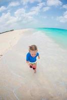 weinig meisje hebben pret in Ondiep water foto