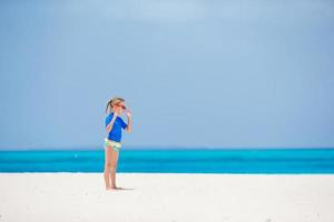 weinig meisje gedurende strand vakantie hebben pret Aan de wit strand foto