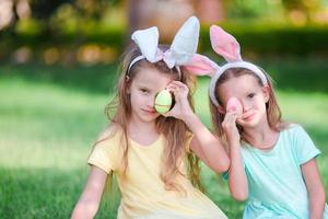 twee schattige zusjes die konijnenoren dragen op paasdag buitenshuis foto