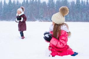 aanbiddelijk weinig meisjes buitenshuis Aan winter sneeuw dag foto