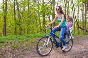 gelukkig moeder en weinig dochter wielersport fiets Bij de park foto