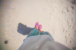 detailopname van een vrouw voet in de schalie Aan zand strand foto
