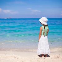 terug visie van aanbiddelijk weinig meisje Aan tropisch strand foto