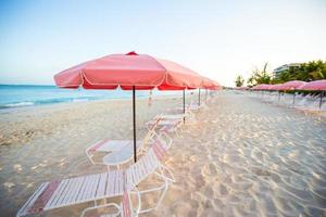 tropisch leeg zanderig strand met paraplu en strand stoel foto